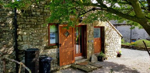マトロックにあるChestnut Farm Holiday Cottagesの木製のドアと窓のある石造りの家