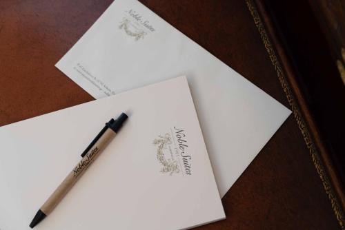 a pen sitting on top of white papers on a table at Noble Suites in Athens