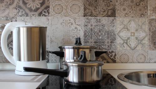 two silver pots sitting on top of a stove at Archinuè in Siracusa