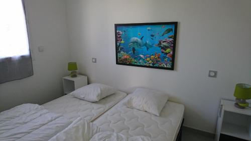 ポルト・ヴェッキオにあるJolie Mini-villa 70 m2のベッドルーム1室(ベッド2台付)が備わります。壁には絵画が飾られています。