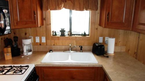 a kitchen with a sink and a stove and a window at Cedar Pines Resort in South Lake Tahoe