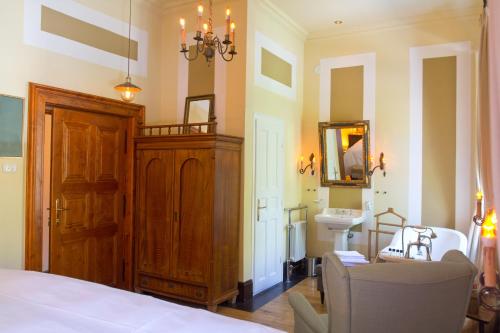a bedroom with a bed and a sink and a mirror at Zabola Estate - Transylvania in Zăbala