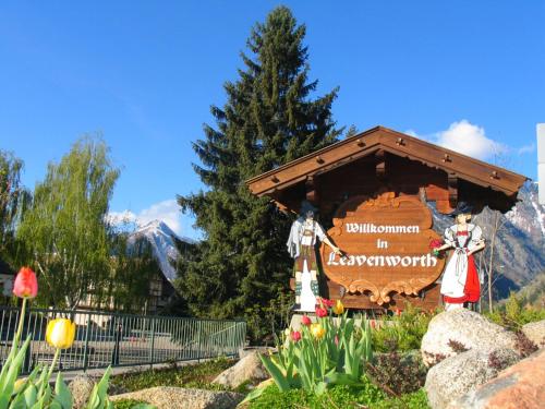 a sign in a garden in front of a mountain at Alpine Rivers Inn in Leavenworth