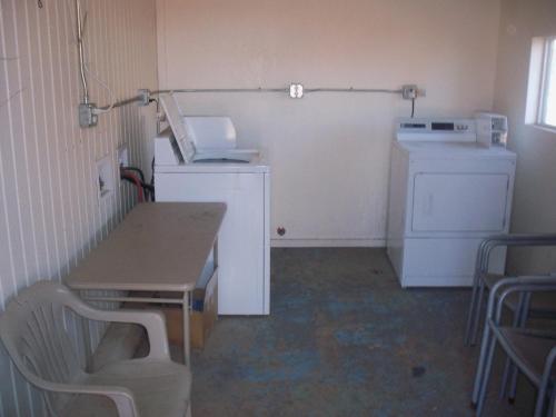 a kitchen with a table and a washer and dryer at Deluxe Inn Of Roswell in Roswell