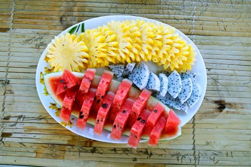 Zen Hoian Villa في هوي ان: طبق من الطعام مع الفاكهة والمقرمشات على الطاولة