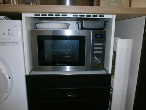 Un horno microondas colocado encima de un armario. en Studio équipé avec jardin+parking à la plage..., en La Ciotat