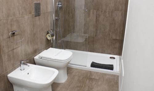 a bathroom with a toilet and a sink and a shower at Archinuè in Siracusa