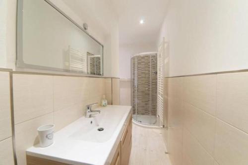 a white bathroom with a sink and a mirror at La Casa nel Borgo sul Lago in Pisogne