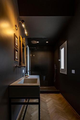 a bathroom with a sink and a bath room at La Maison in Siracusa
