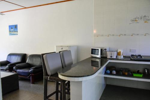 a kitchen with a counter with a table and chairs at HideAway in Anse Possession