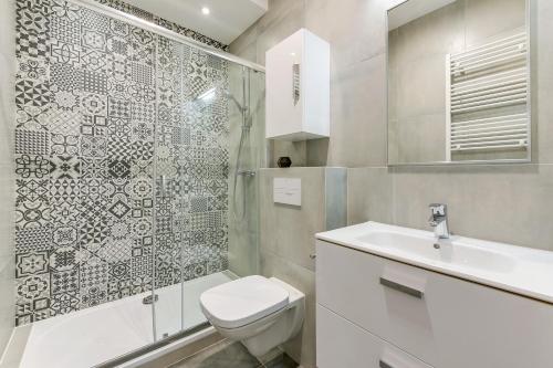 a bathroom with a toilet and a sink and a shower at GRANO APARTMENTS Gdańsk Motława SPA & Wellness in Gdańsk