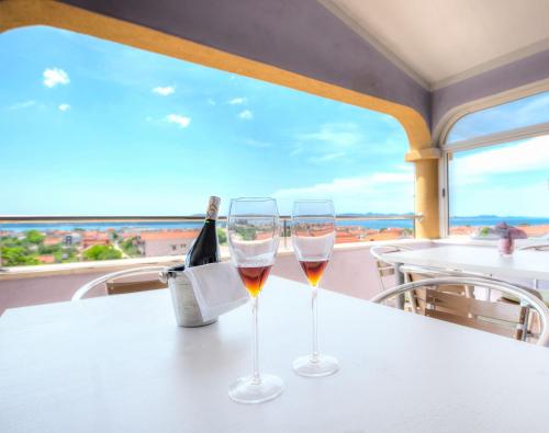 dois copos de vinho numa mesa com vista para o mar em Mareta Guesthouse em Bibinje