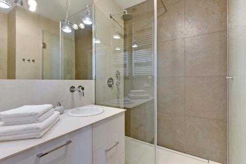 a bathroom with a glass shower and a sink at GRANO APARTMENTS Gdańsk Motława SPA & Wellness in Gdańsk