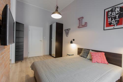 a bedroom with a large bed and a television at GRANO APARTMENTS Gdańsk Motława SPA & Wellness in Gdańsk