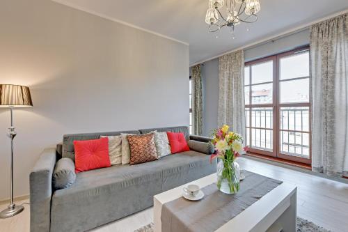 a living room with a couch and a table at GRANO APARTMENTS Gdańsk Motława SPA & Wellness in Gdańsk
