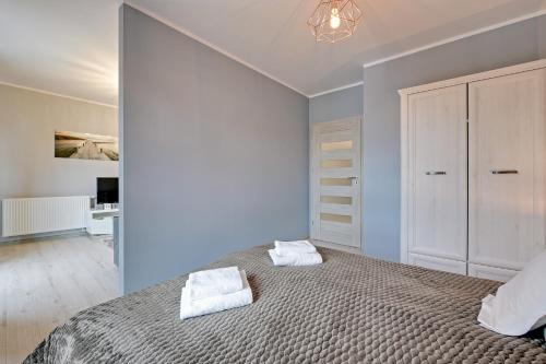 a bedroom with a large bed with two towels on it at GRANO APARTMENTS Gdańsk Motława SPA & Wellness in Gdańsk