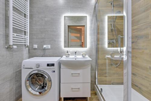 a bathroom with a washing machine and a sink at GRANO APARTMENTS Gdańsk Motława SPA & Wellness in Gdańsk