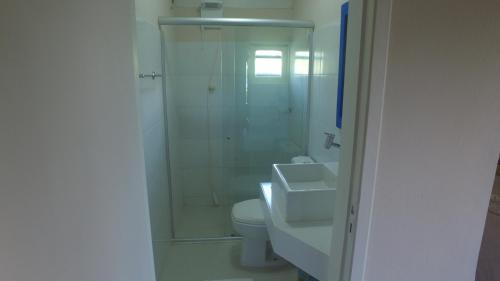 a bathroom with a shower and a toilet and a sink at Pousada o Forte in Mangue Sêco