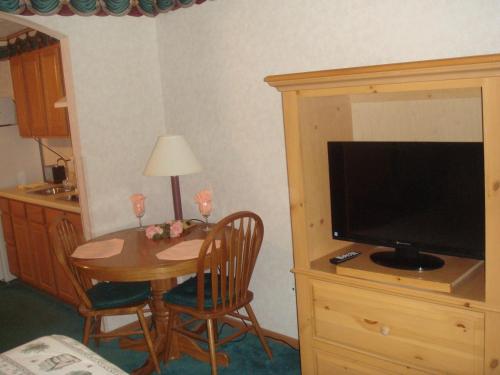 a room with a table with a television and a dining room at Townhouse Inn & Suites Omaha in Omaha