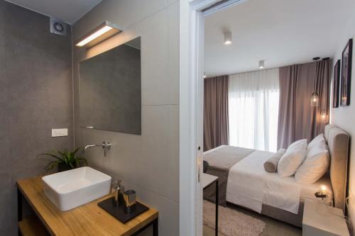 bagno con letto, lavandino e specchio di Guest House Blanka a Trogir