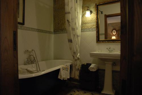een badkamer met een ligbad en een wastafel bij Casa do Meio do Povo - Turismo de Habitação in Chaves