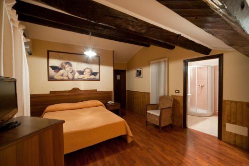 a bedroom with a bed and a tv and a chair at Hostaria da Lino in San Marino