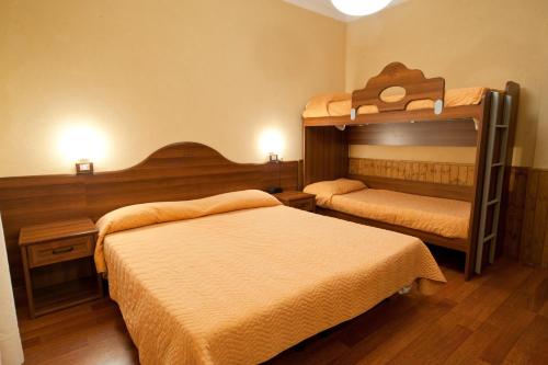 a hotel room with two beds and two bunk beds at Hostaria da Lino in San Marino