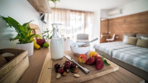 un tavolo con un tagliere con frutta e una bottiglia di latte di The Poolhouse a Sunny Beach
