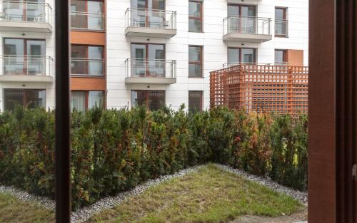 a building with a garden in front of a building at GRANO APARTMENTS Gdańsk Motława SPA & Wellness in Gdańsk