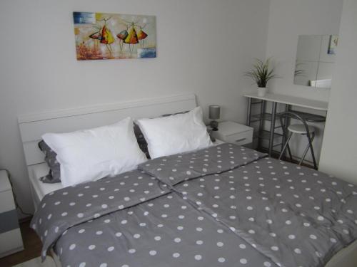 a bedroom with a bed with polka dot sheets at Apartman TIM in Osijek