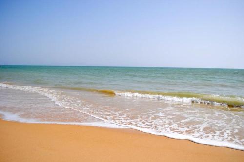 a beach with the ocean and the shoreline at Maison d'Hôtes entière Cité Douane Golf Dakar in Dakar