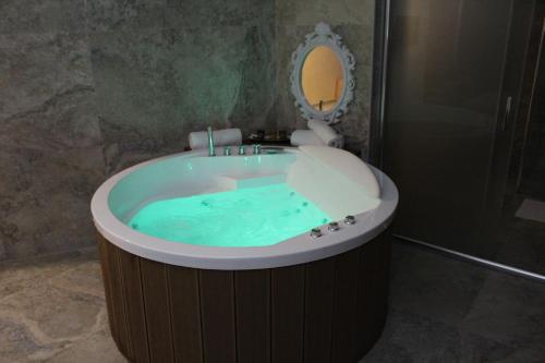 a bathroom with a tub filled with blue water at Ideal city in Tutin