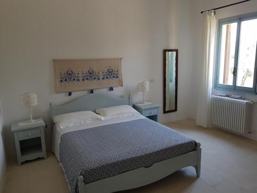 ウッジャーノ・ラ・キエーザにあるMasseria Vignenoveのベッドルーム1室(ベッド1台、ランプ2つ、鏡付)