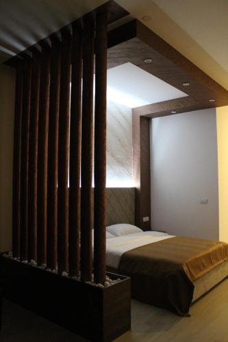 a bedroom with a bed in a room with wooden beams at Ideal city in Tutin