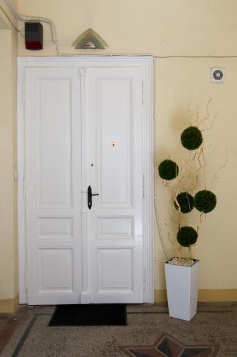 a white door in a room with plants on the wall at Apartment HYGGE in Subotica