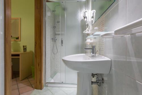 a white bathroom with a sink and a shower at Le Dimore dei Messapi in Ugento