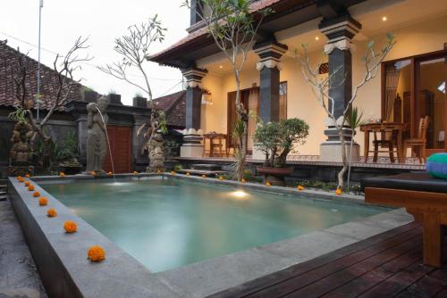 a swimming pool in front of a house at Suparsa's Homestay in Ubud