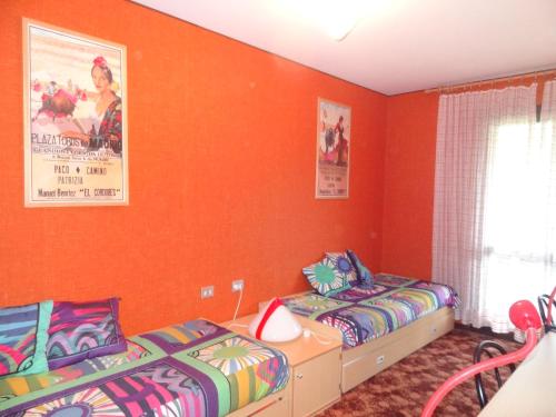 two beds in a room with orange walls at Casa Vacanza Caspoggio in Caspoggio