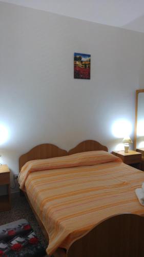 Bett in einem Zimmer mit 2 Tischen und 2 Lampen in der Unterkunft Appartamenti S'Agapo' in Catanzaro Lido