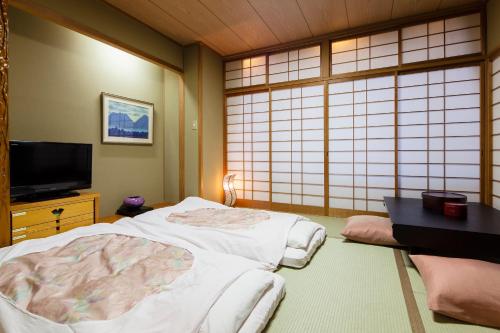 Postel nebo postele na pokoji v ubytování Yamatoya Honten Ryokan Osaka