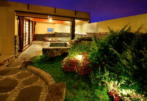 a backyard with a garden with flowers and a building at Ming Lu Holiday Hotel in Renai