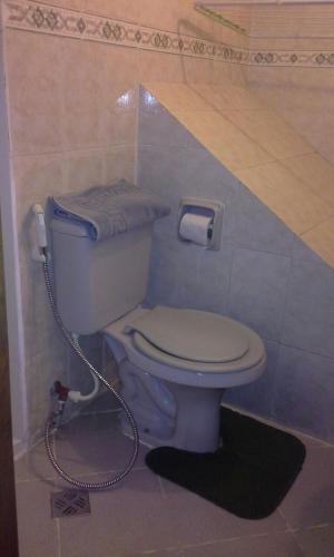 a bathroom with a toilet with a hose connected to it at Edificio Ambay Roga in Asuncion