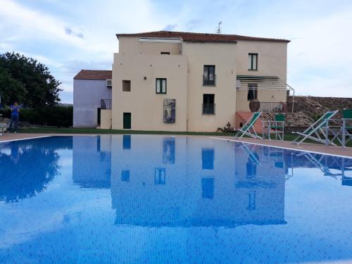 une maison et une piscine en face d'un bâtiment dans l'établissement Barone GR Macrì Agriturismo Modi, à Gerace