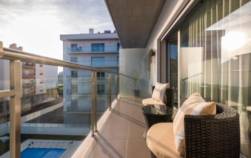 a balcony with chairs and a view of a building at Alto das Nogueiras House Fátima in Fátima