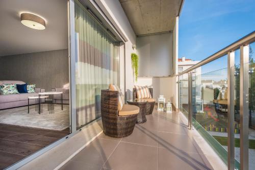 a balcony with chairs and tables on a building at Alto das Nogueiras House Fátima in Fátima
