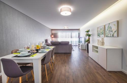 a dining room and living room with a white table and chairs at Alto das Nogueiras House Fátima in Fátima