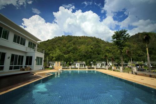a large swimming pool with a mountain in the background at Yura Kiri Resort Khao Yai in Mu Si