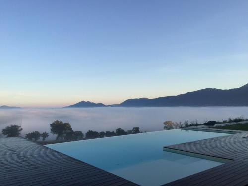 a swimming pool on the roof of a house with a view of the fog at Serre Alte Landscape Luxury Rooms in Matelica