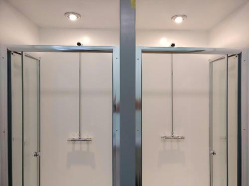 szereg szklanych drzwi w pokoju z oświetleniem w obiekcie Birmingham Central Backpackers w Birmingham