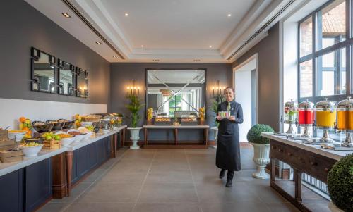 a woman standing in front of a store with a counter at Castletroy Park Hotel Suites in Limerick